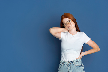 Image showing Caucasian young girl\'s portrait isolated on blue studio background. Beautiful female model. Concept of human emotions, facial expression, sales, ad, youth culture.