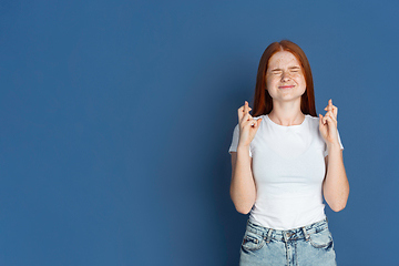 Image showing Caucasian young girl\'s portrait isolated on blue studio background. Beautiful female model. Concept of human emotions, facial expression, sales, ad, youth culture.