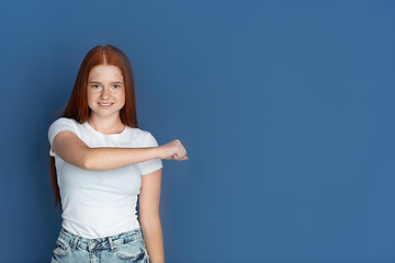 Image showing Caucasian young girl\'s portrait isolated on blue studio background. Beautiful female model. Concept of human emotions, facial expression, sales, ad, youth culture.