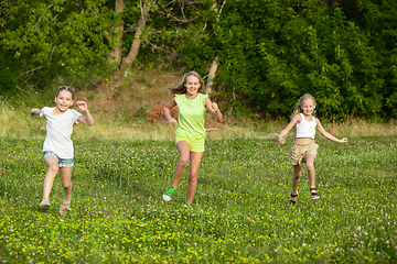 Image showing Kids, children running on meadow in summer\'s sunlight