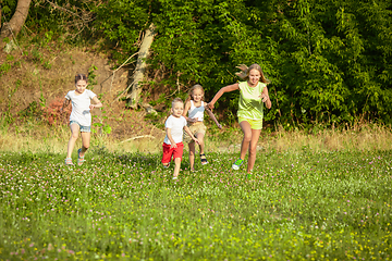 Image showing Kids, children running on meadow in summer\'s sunlight