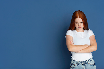 Image showing Caucasian young girl\'s portrait isolated on blue studio background. Beautiful female model. Concept of human emotions, facial expression, sales, ad, youth culture.