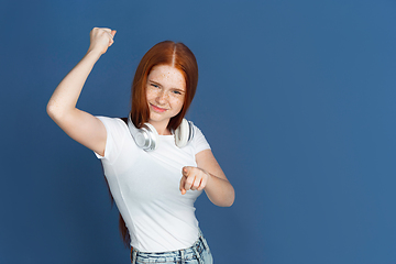 Image showing Caucasian young girl\'s portrait isolated on blue studio background. Beautiful female model. Concept of human emotions, facial expression, sales, ad, youth culture.