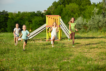 Image showing Kids, children running on meadow in summer\'s sunlight