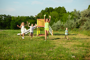 Image showing Kids, children running on meadow in summer\'s sunlight