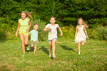 Image showing Kids, children running on meadow in summer\'s sunlight