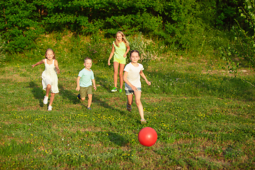 Image showing Kids, children running on meadow in summer\'s sunlight