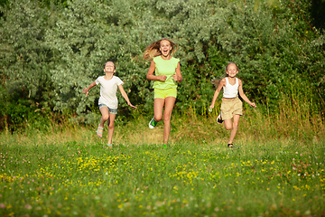 Image showing Kids, children running on meadow in summer\'s sunlight