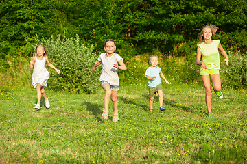 Image showing Kids, children running on meadow in summer\'s sunlight