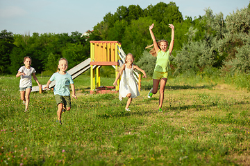 Image showing Kids, children running on meadow in summer\'s sunlight