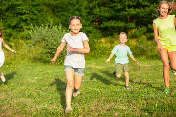 Image showing Kids, children running on meadow in summer\'s sunlight