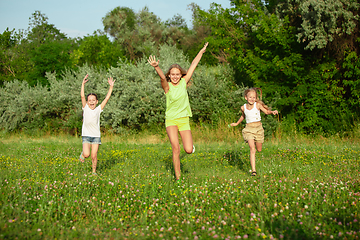 Image showing Kids, children running on meadow in summer\'s sunlight