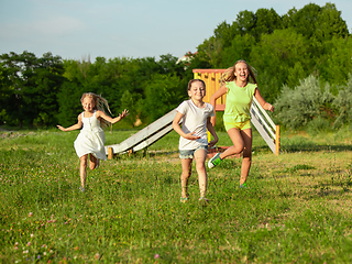 Image showing Kids, children running on meadow in summer\'s sunlight