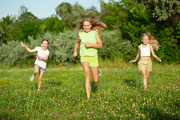 Image showing Kids, children running on meadow in summer\'s sunlight