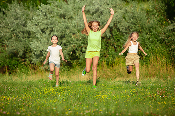 Image showing Kids, children running on meadow in summer\'s sunlight