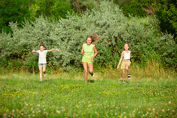 Image showing Kids, children running on meadow in summer\'s sunlight