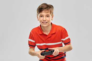 Image showing smiling boy with gamepad playing video game