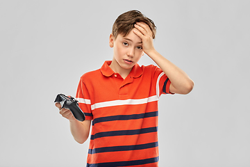 Image showing unhappy boy with gamepad playing video game