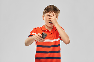 Image showing scared boy with tv remote control