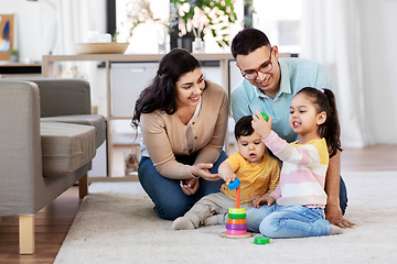 Image showing happy family playing with pyramid toy at home
