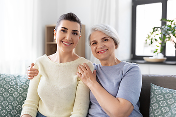 Image showing senior mother with adult daughter hugging at home