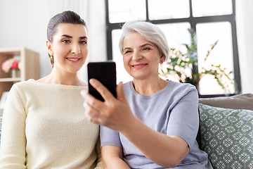 Image showing senior mother with daughter taking selfie at home