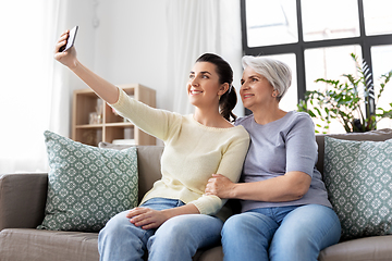 Image showing senior mother with daughter taking selfie at home