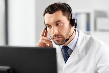 Image showing male doctor with computer and headset at hospital