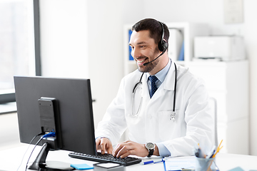 Image showing happy doctor with computer and headset at hospital