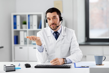 Image showing male doctor in headset having video call at clinic