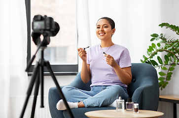 Image showing female beauty blogger with camera and mascara