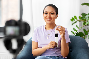 Image showing female blogger with camera video blogging at home