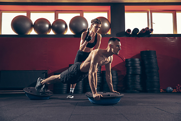 Image showing Beautiful young sporty couple training, workout in gym together