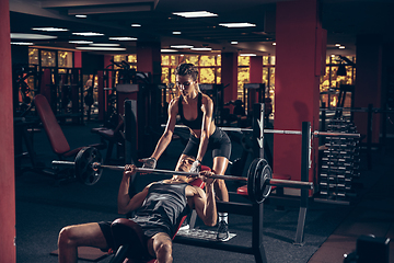 Image showing Beautiful young sporty couple training, workout in gym together