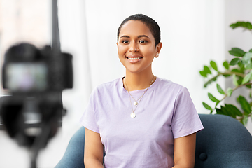 Image showing female blogger with camera video blogging at home