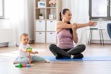 Image showing happy mother with little baby exercising at home