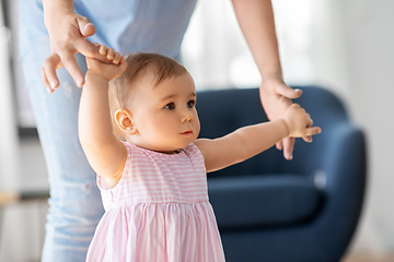 Image showing baby girl learning to walk with mother's help