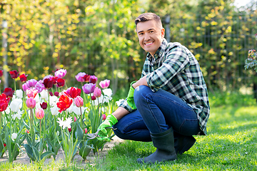 Image showing man with pruner taking care of flowers at garden