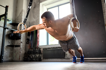 Image showing man doing exercising on gymnastic rings in gym