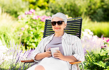 Image showing happy senior woman drinking coffee at garden