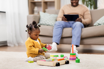 Image showing african baby girl playing with toy blocks at home