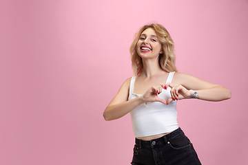 Image showing Caucasian young woman\'s portrait isolated on pink studio background. Beautiful female model. Concept of human emotions, facial expression, sales, ad, youth culture.