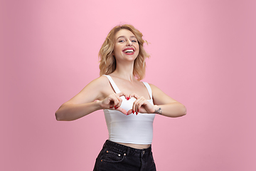 Image showing Caucasian young woman\'s portrait isolated on pink studio background. Beautiful female model. Concept of human emotions, facial expression, sales, ad, youth culture.