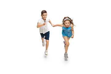 Image showing Happy little caucasian girl and boy jumping and running isolated on white background