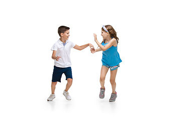 Image showing Happy little caucasian girl and boy jumping and running isolated on white background