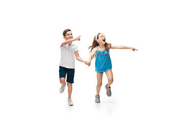 Image showing Happy little caucasian girl and boy jumping and running isolated on white background