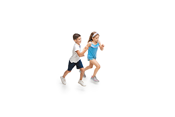 Image showing Happy little caucasian girl and boy jumping and running isolated on white background