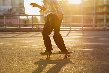 Image showing Skateboarder doing a trick at the city\'s street in summer\'s sunshine