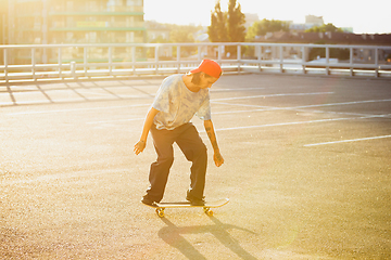 Image showing Skateboarder doing a trick at the city\'s street in summer\'s sunshine