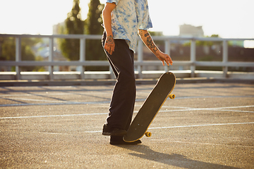 Image showing Skateboarder doing a trick at the city\'s street in summer\'s sunshine